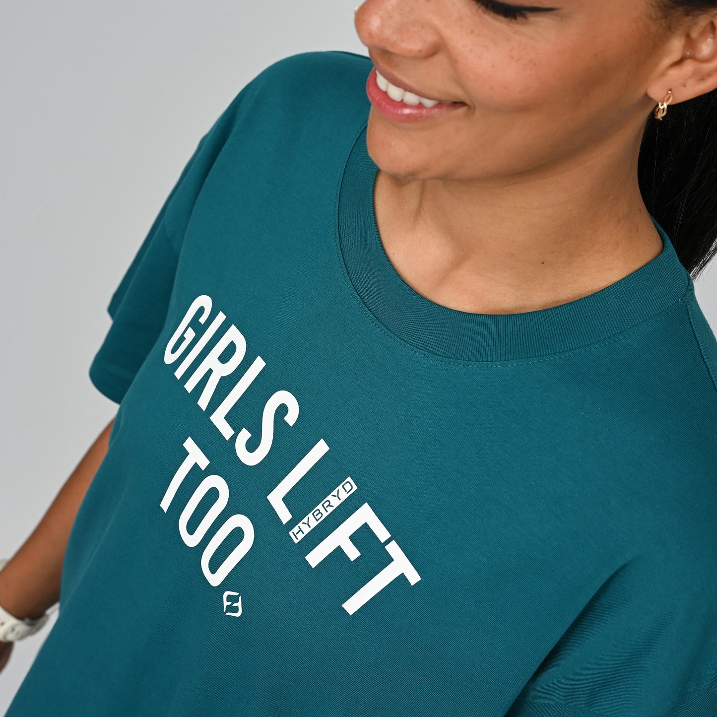 Person wearing a teal t-shirt with 'GIRLS LIFT TOO' text on from Hybryd gymwear