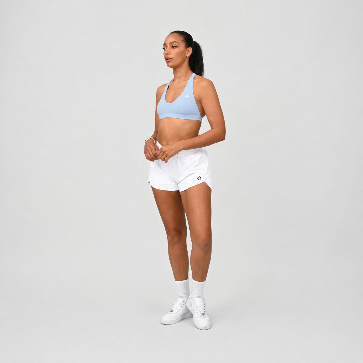 A pair of white run shorts with an inner short and pockets. An elastictic waistband. Made for running from activewear brand Hybryd. Worn with a sky blue sports bra. 