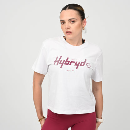 Woman wearing a boxy white t-shirt with 'Hybryd' logo on a plain background