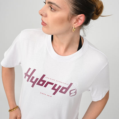 Woman wearing a white training  t-shirt with 'Hybryd' logo on a plain background