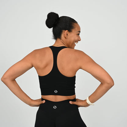 CrossFit athlete wearing a black square neck, muscle back sports bra with matching cinch bum bootie shorts from the gymwear brand Hybryd.