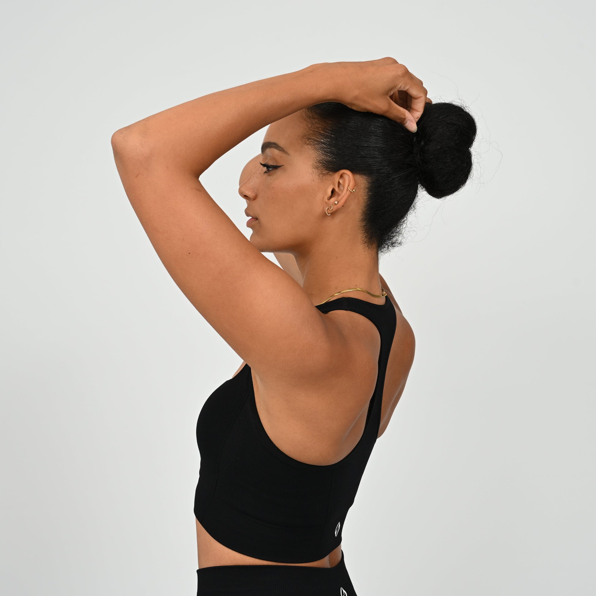 CrossFit athlete wearing a black square neck, muscle back sports bra with matching cinch bum bootie shorts from the gymwear brand Hybryd.