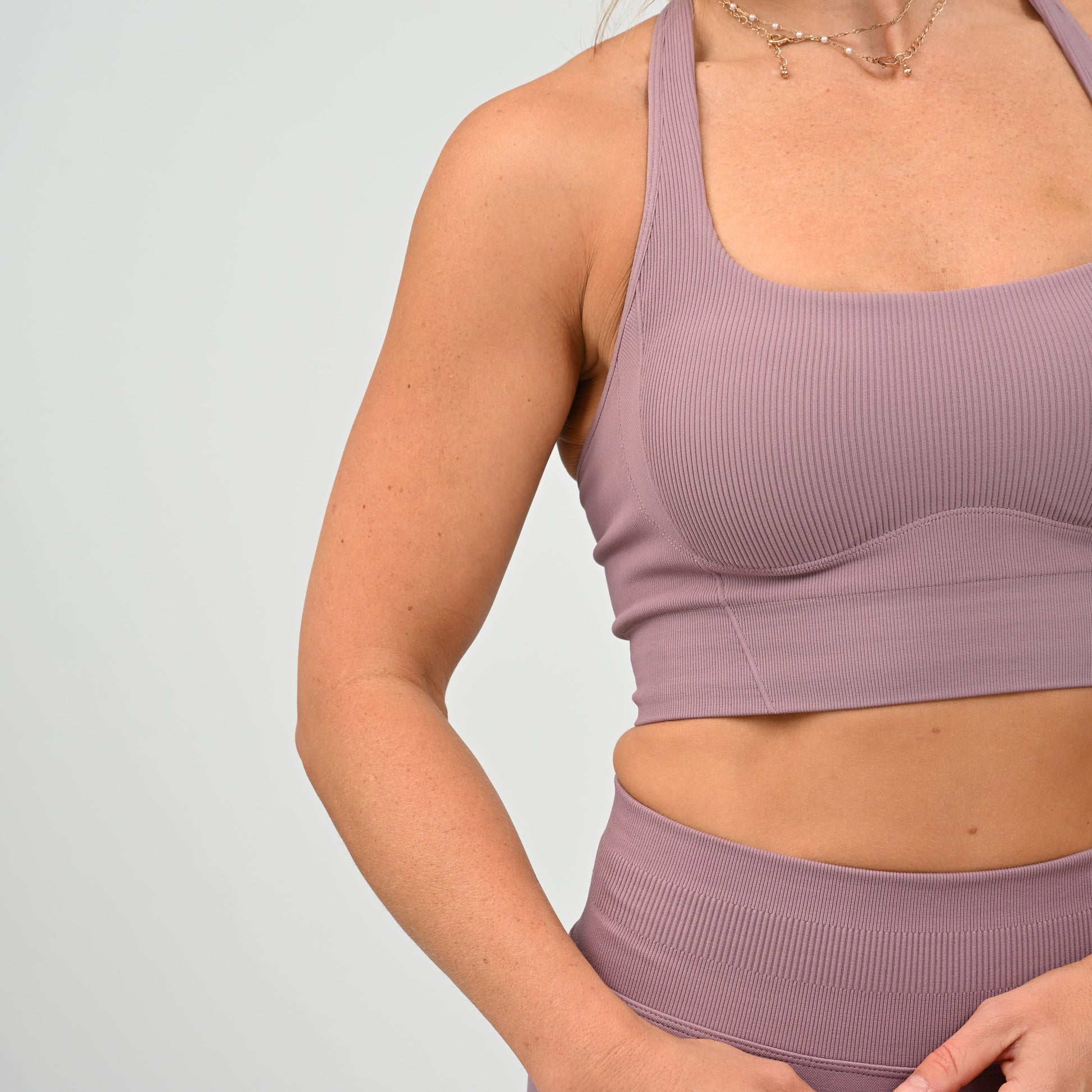 CrossFit athlete wearing a mauve square neck, muscle back sports bra with matching cinch bum bootie shorts from the gymwear brand Hybryd.