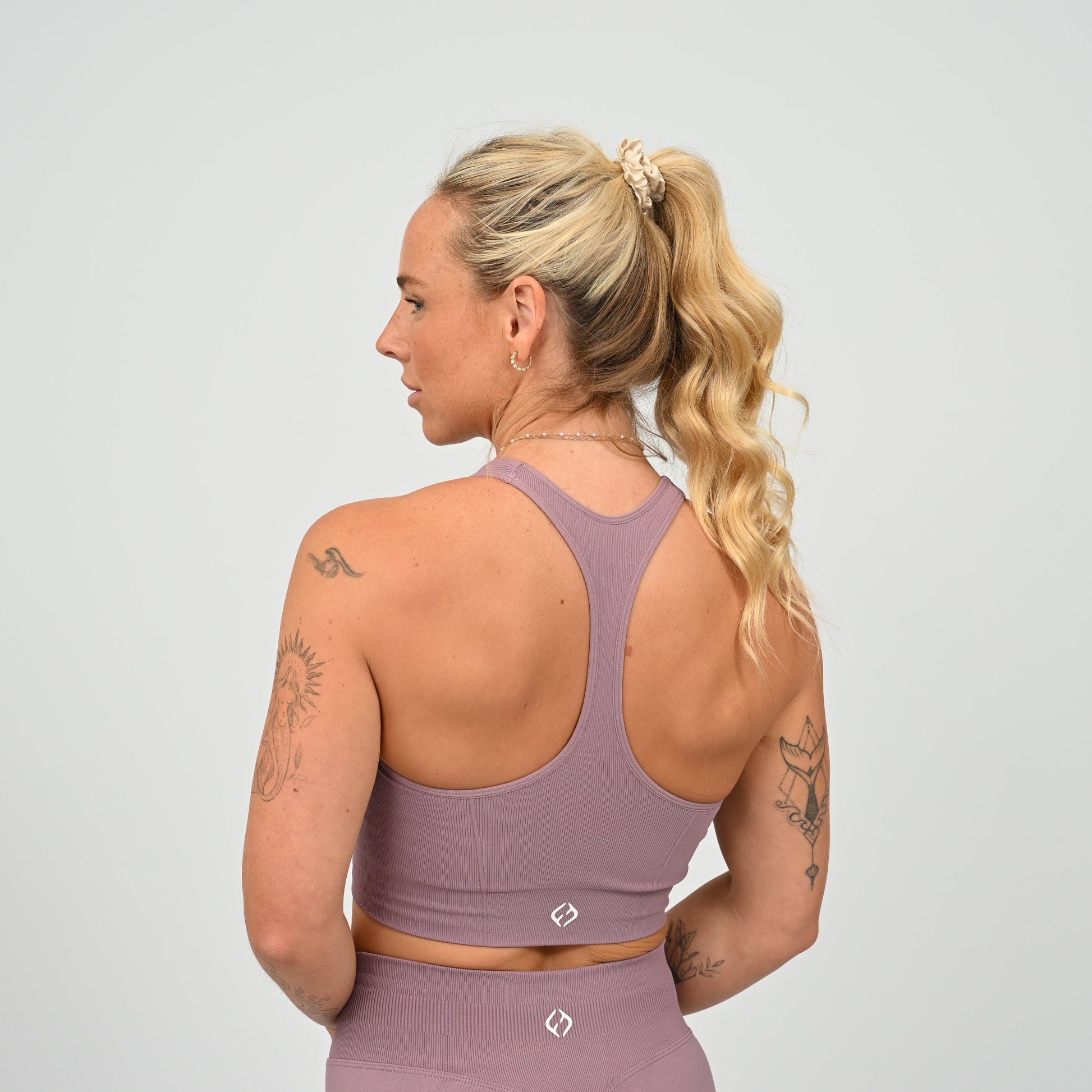 CrossFit athlete wearing a mauve square neck, muscle back sports bra with matching cinch bum bootie shorts from the gymwear brand Hybryd.