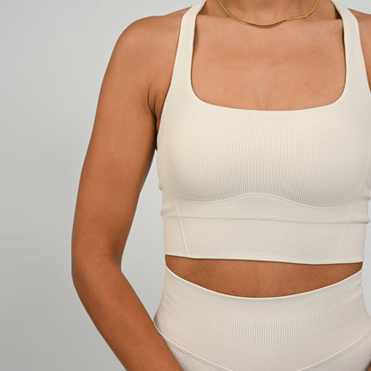 CrossFit athlete wearing a off white square neck, muscle back sports bra with matching cinch bum bootie shorts from the gymwear brand hybryd.