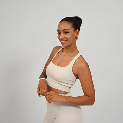 CrossFit athlete wearing a off white square neck, muscle back sports bra with matching cinch bum bootie shorts from the gymwear brand hybryd.