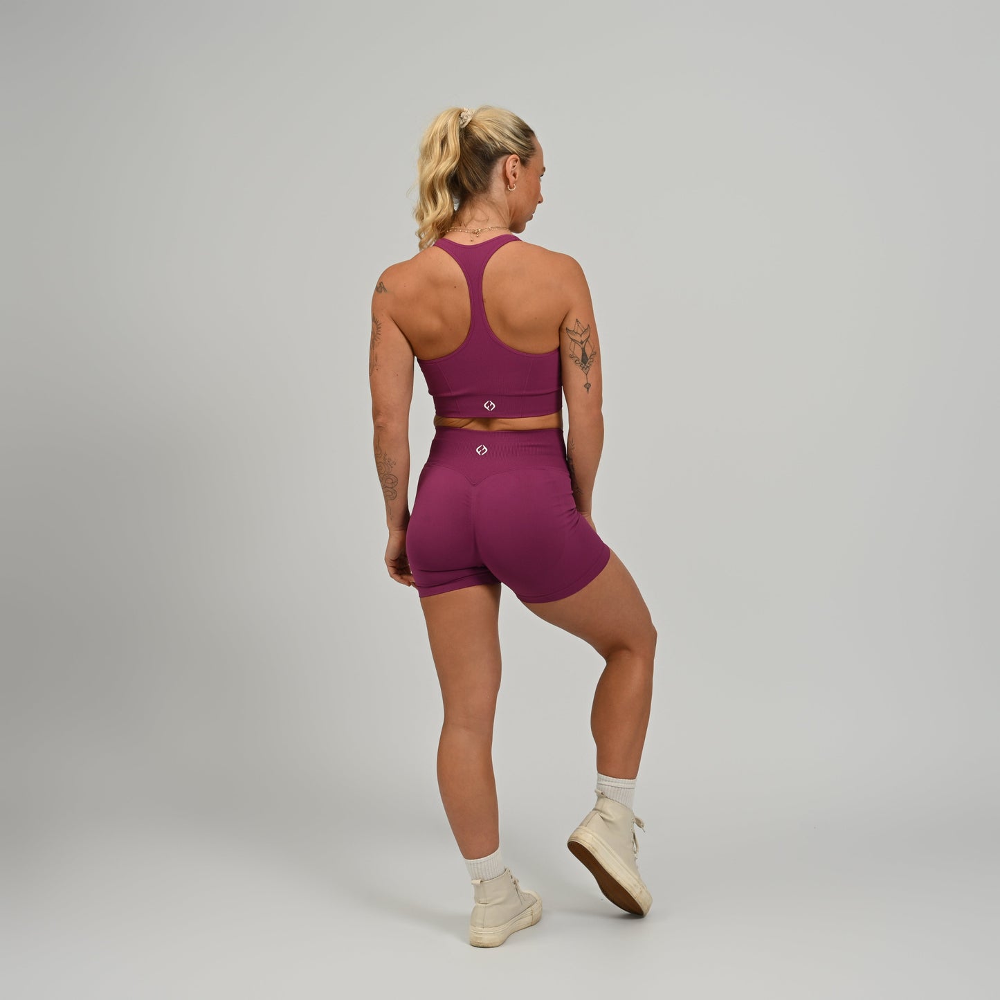 CrossFit athlete wearing a purple square neck, muscle back sports bra with matching leggings from the gymwear brand hybryd.