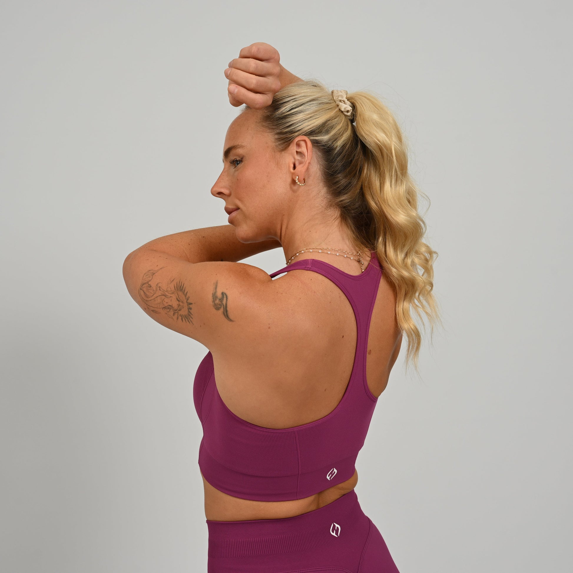 CrossFit athlete wearing a purple square neck, muscle back sports bra with matching leggings from the gymwear brand hybryd.