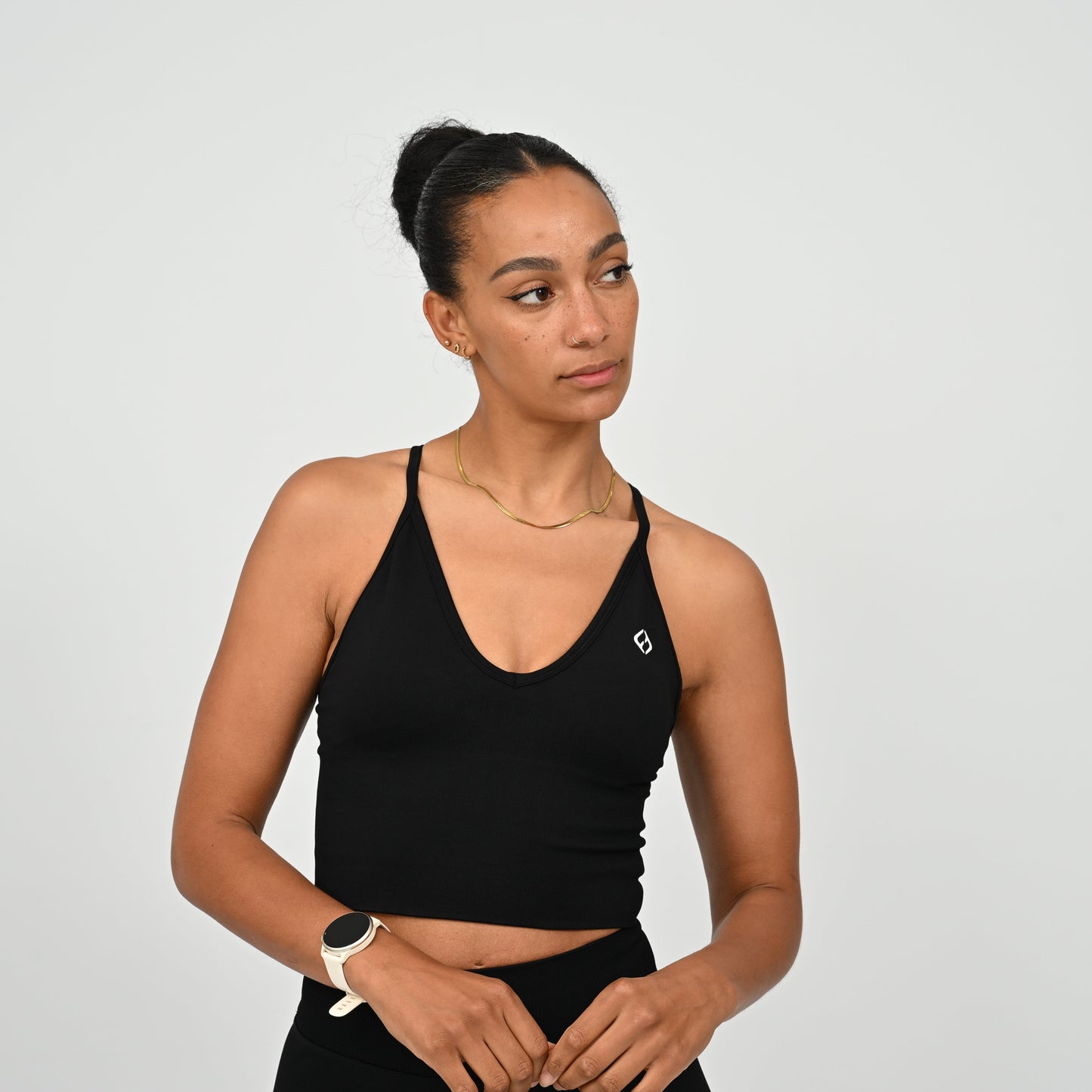 Crossfit girl wearing a black ribbed workout vest with removable pads and crossover straps. Made by gymwear brand Hybryd