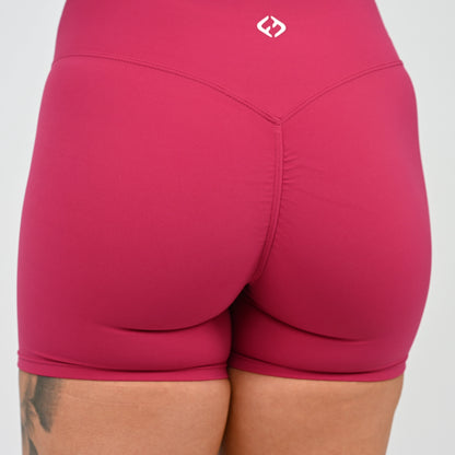 Close-up back view of a person wearing cinch bum shorts with a small white Hybryd logo near the waistband, against a light gray background.