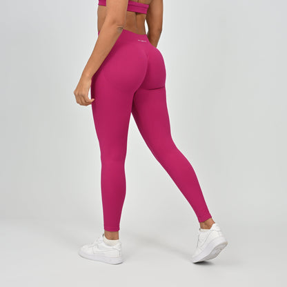 Woman wearing bright pink Hybryd gym leggings and a matching top. 