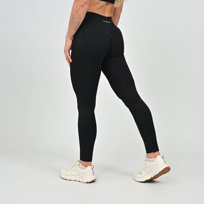 Woman wearing black Hybryd gym leggings with a visible brand logo .