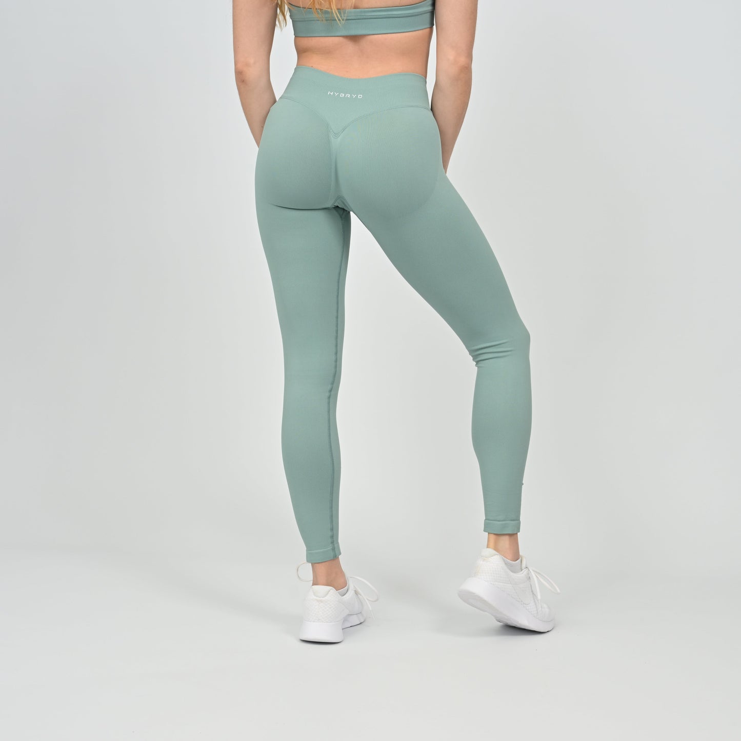Person wearing light green Hybryd  leggings with a scrunch bum