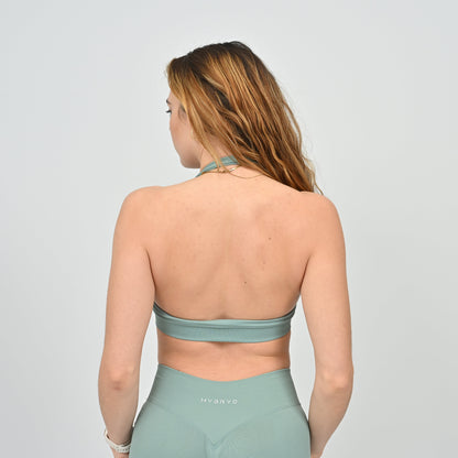 Woman wearing a seafoam sports bra and leggings from actiewear brand Hybryd