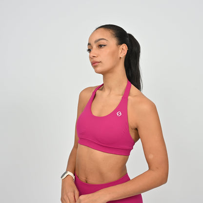 Woman wearing a pink Hybryd sports bra with removable pads and matching colour leggings