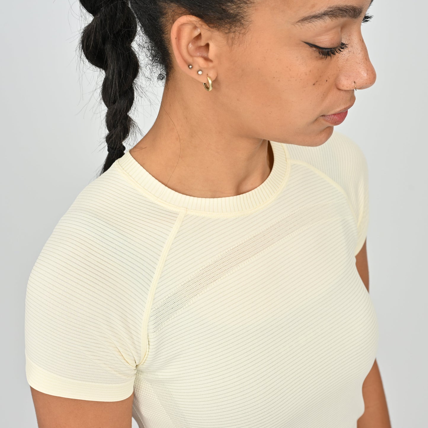 Woman wearing a light-colored athletic T-shirt from the brand Hybryd