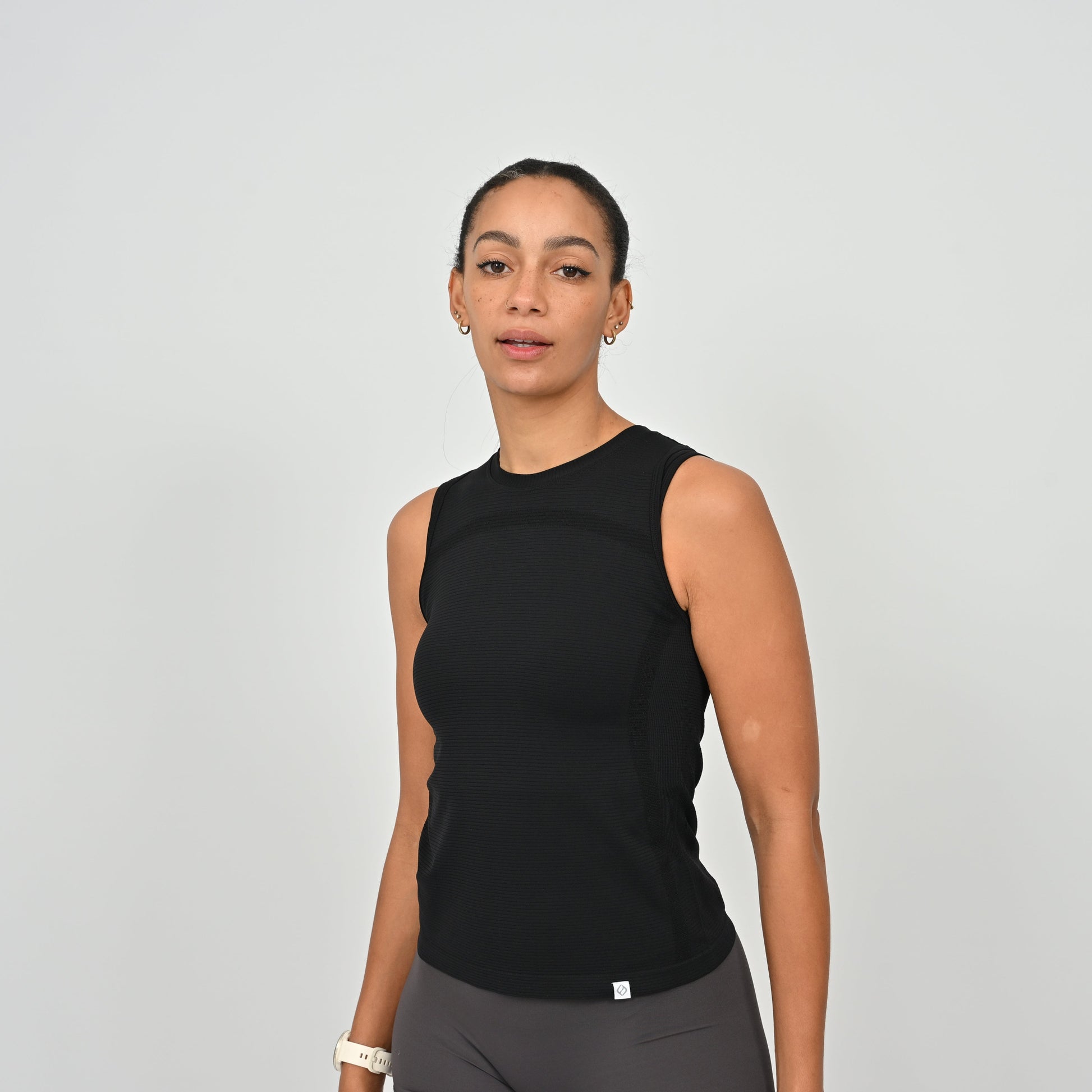 Woman wearing a Hybryd black sleeveless gym vest.