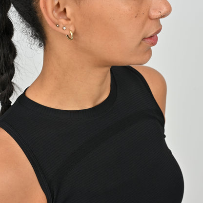 Close-up of a person wearing a black sleeveless activewear vest top from gymwear brand Hybryd