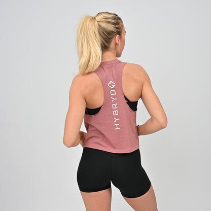 Woman wearing a pink tank top with 'HYBRyD' branding on the back, standing against a gray background.