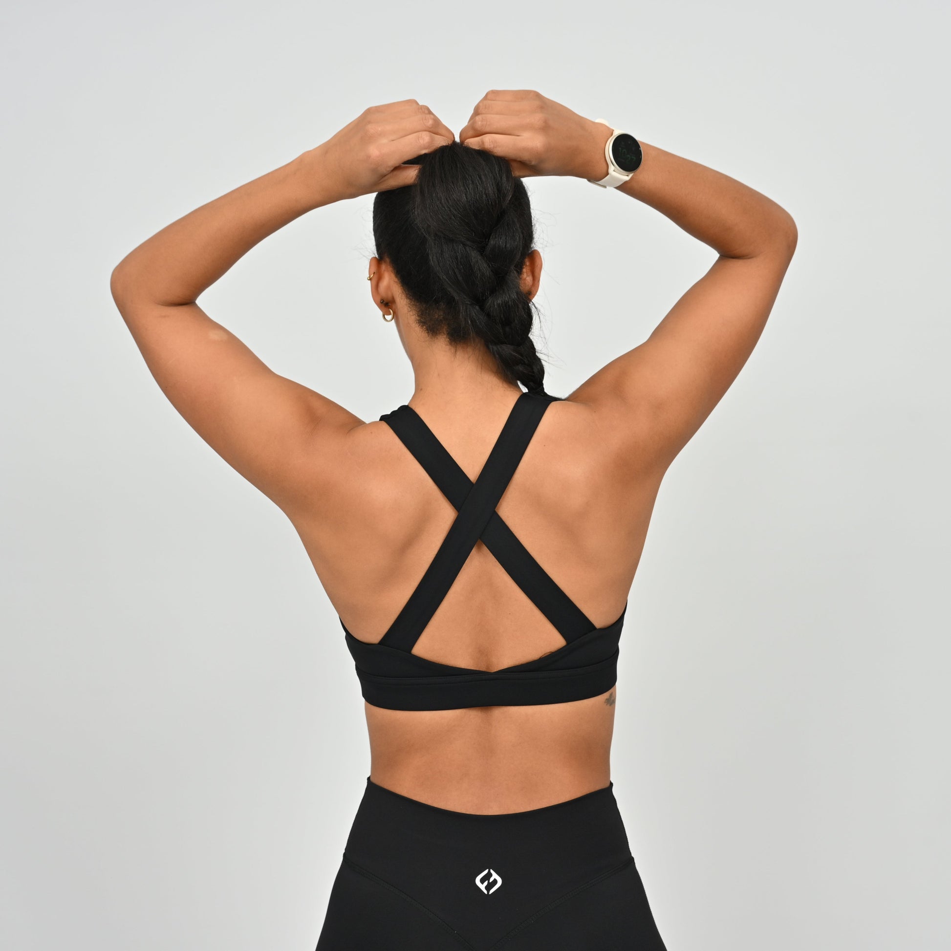 Person wearing a black Hybryd sports bra with criss-cross straps.
