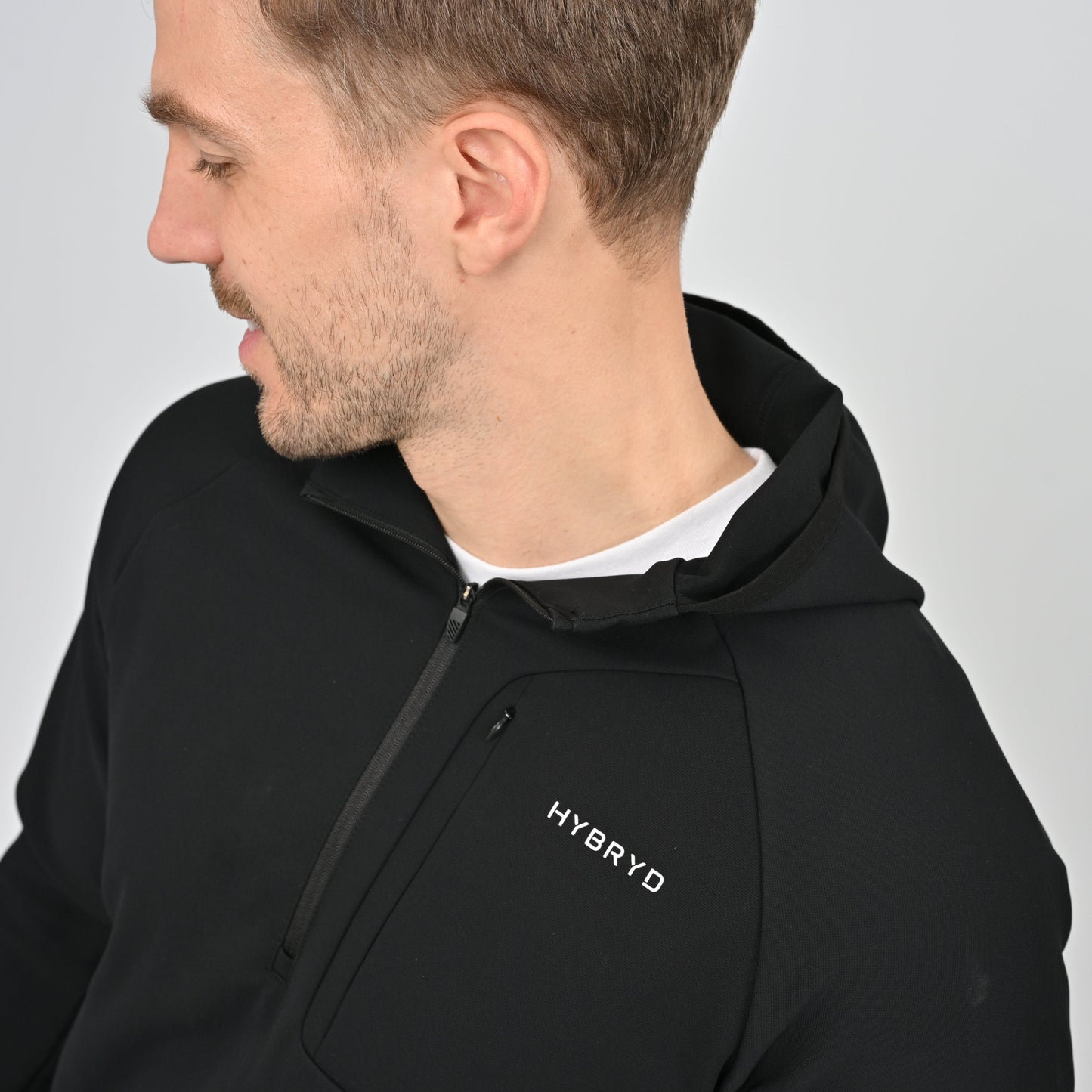 Man wearing a black hoodie with 'HYBRYD' logo on a gray background