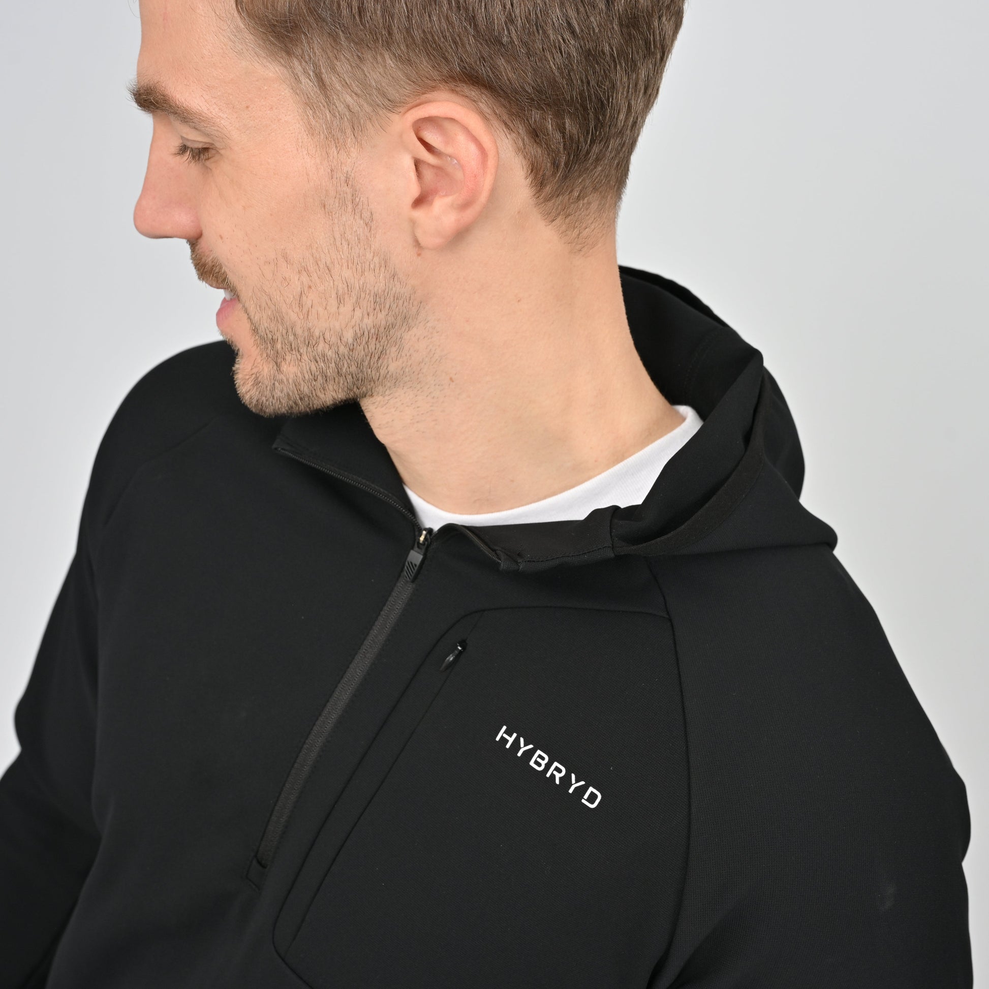 Man wearing a black hoodie with 'HYBRYD' logo on a gray background