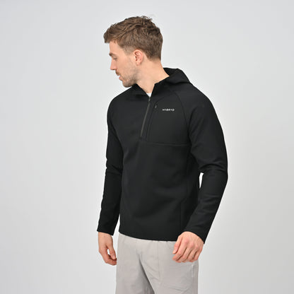 Man wearing a black 1/4 zip jacket with a Hybryd logo on a light gray background