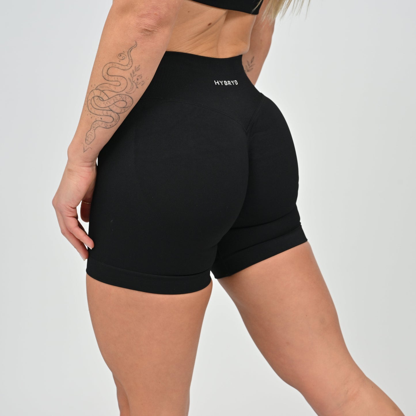 Person wearing hybryd black athletic shorts with a scrunch bum