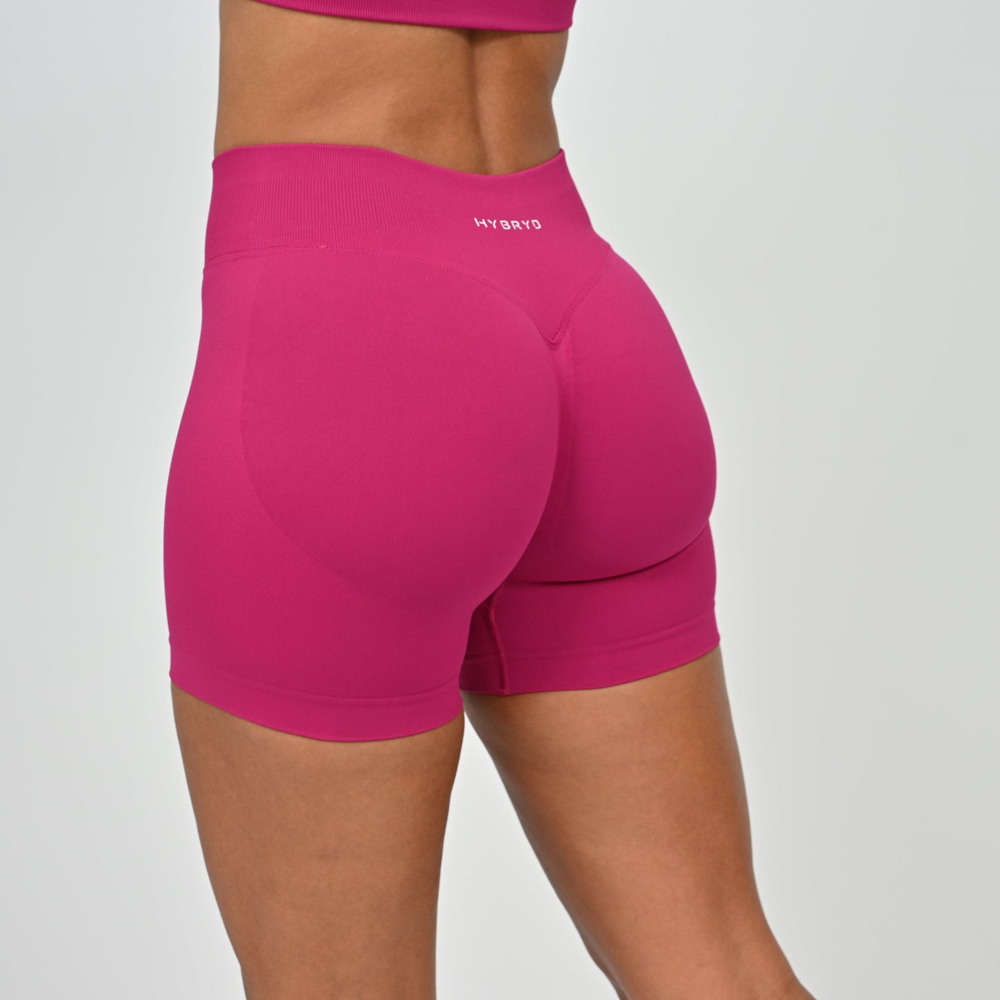 Pink Hybryd athletic shorts with a scunch bum on a gray background