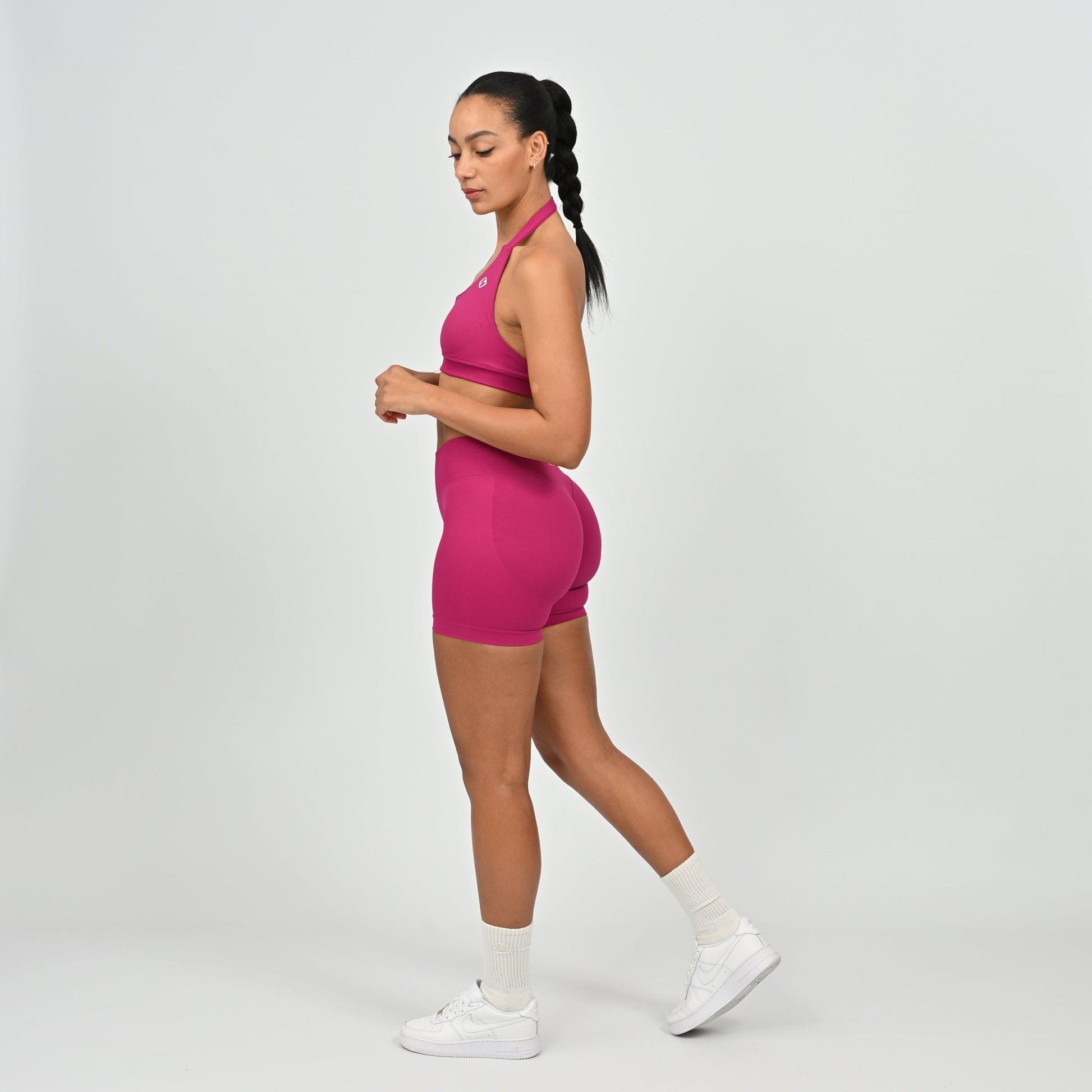 Woman wearing a pink Hybryd athletic outfit on a white background