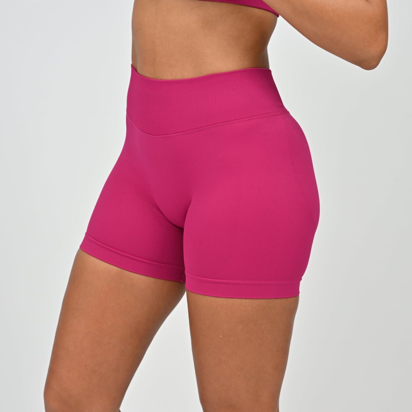 Pink Hybryd training shorts worn by a person on a plain background