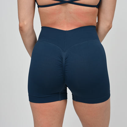 Navy blue athletic crossfit shorts with a bum scrunch worn by a Hybryd athlete on a light gray background