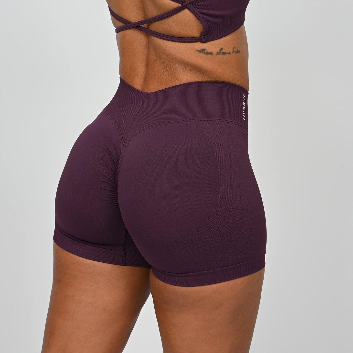 Purple Hybryd athletic shorts with a v-dip waist and scrunch worn by a crossfit athlete on a plain background