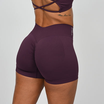 Purple Hybryd athletic shorts with a v-dip waist and scrunch worn by a crossfit athlete on a plain background