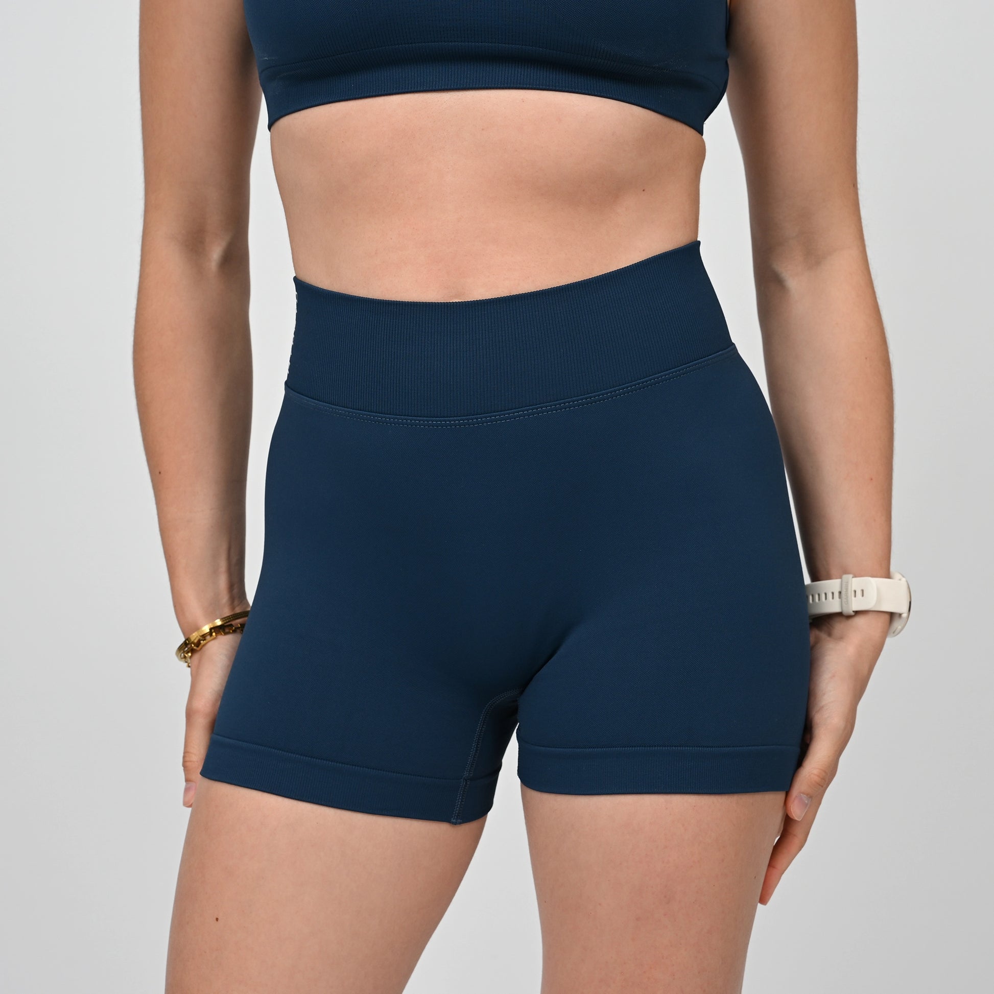 Hybryd athlete wearing navy blue workout gym shorts on a light gray background