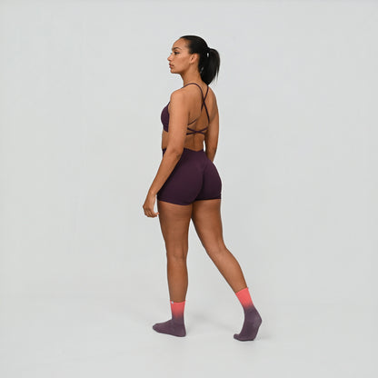 Crossfit athlete wearing a dark purple Hybryd gym outfit on a light gray background