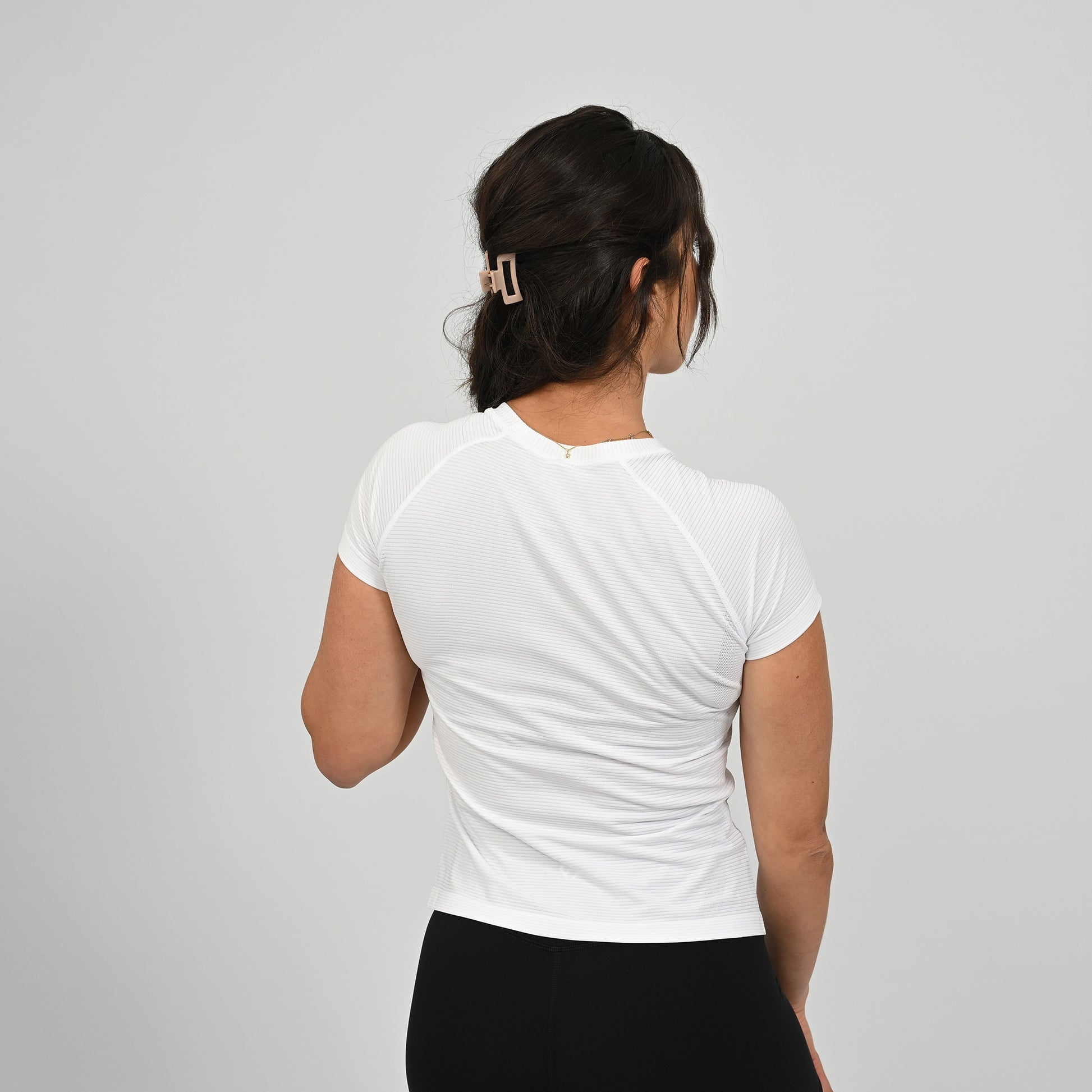 Crossfit athlete wearing a white ribbed Hybryd t-shirt on a plain background