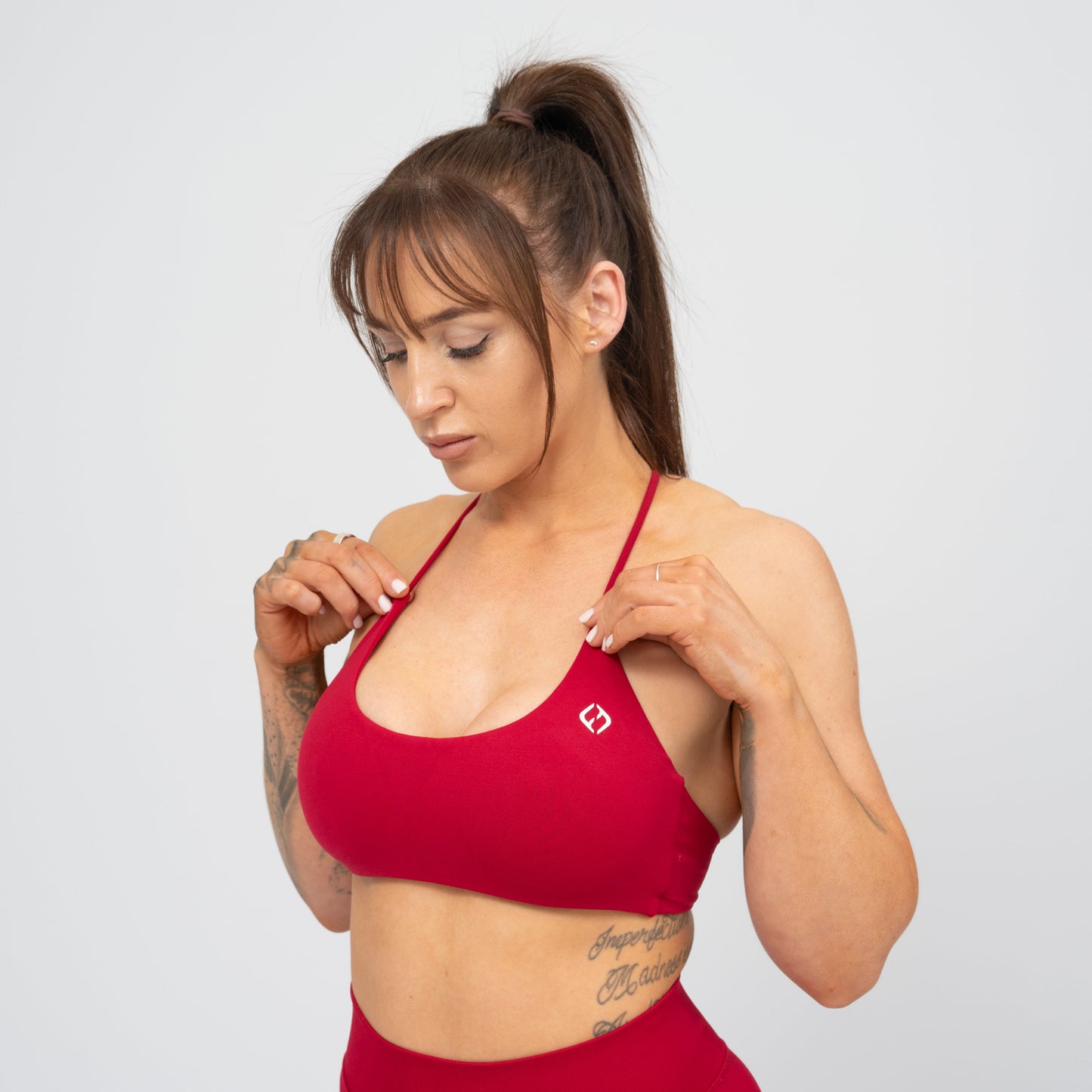 A woman wearing a red Hybryd minimal sports bra