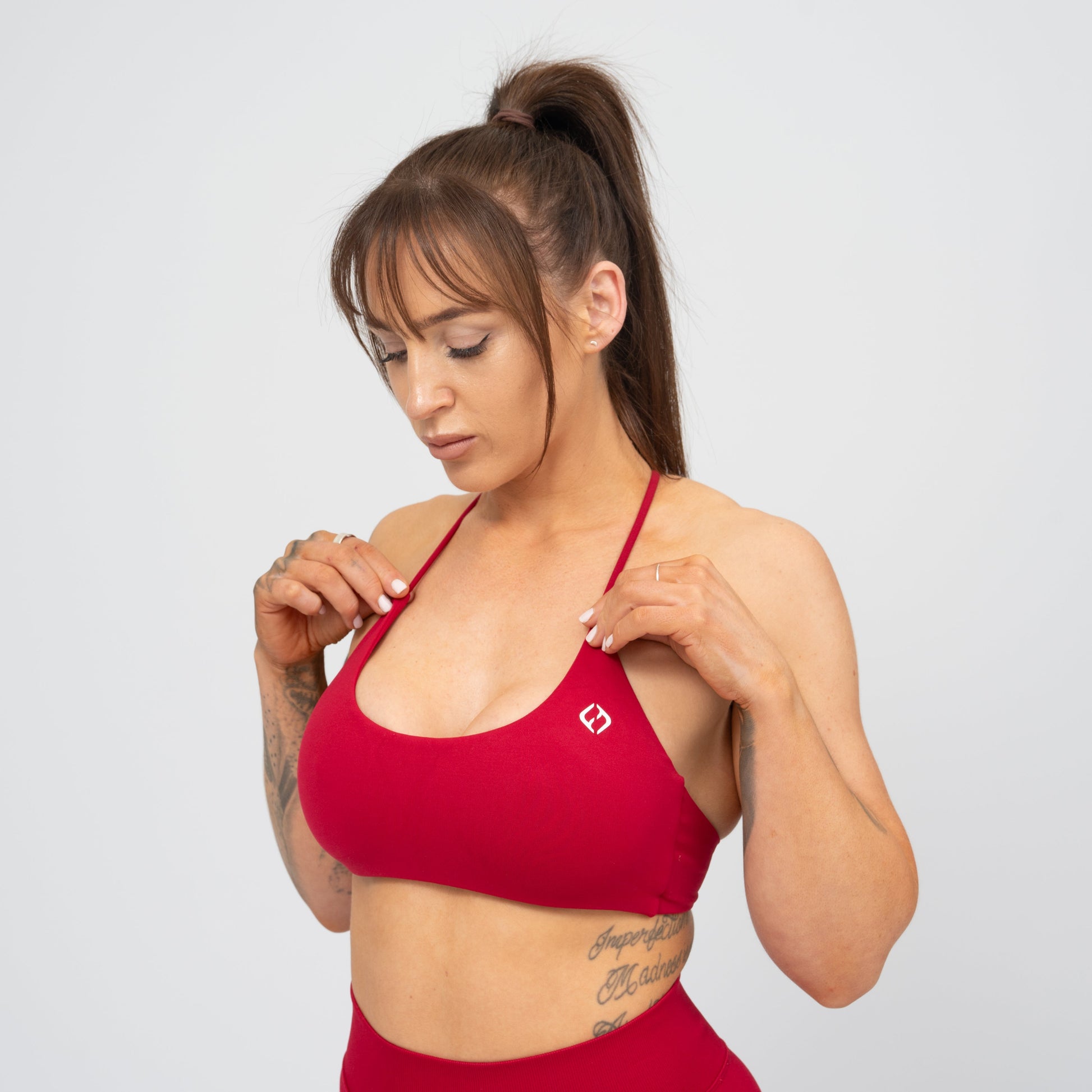 A woman wearing a red Hybryd minimal sports bra