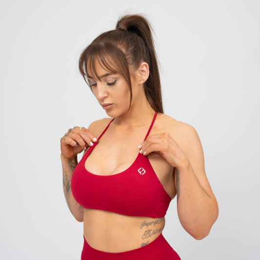 A woman wearing a red Hybryd minimal sports bra