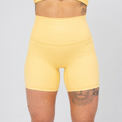 Hybryd yellow high-waisted bike shorts worn by a person on a plain background