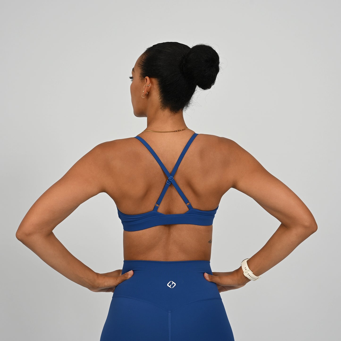 Crossfit athlete wearing an adjustable strap bra and matching leggings with Hybryd logo.