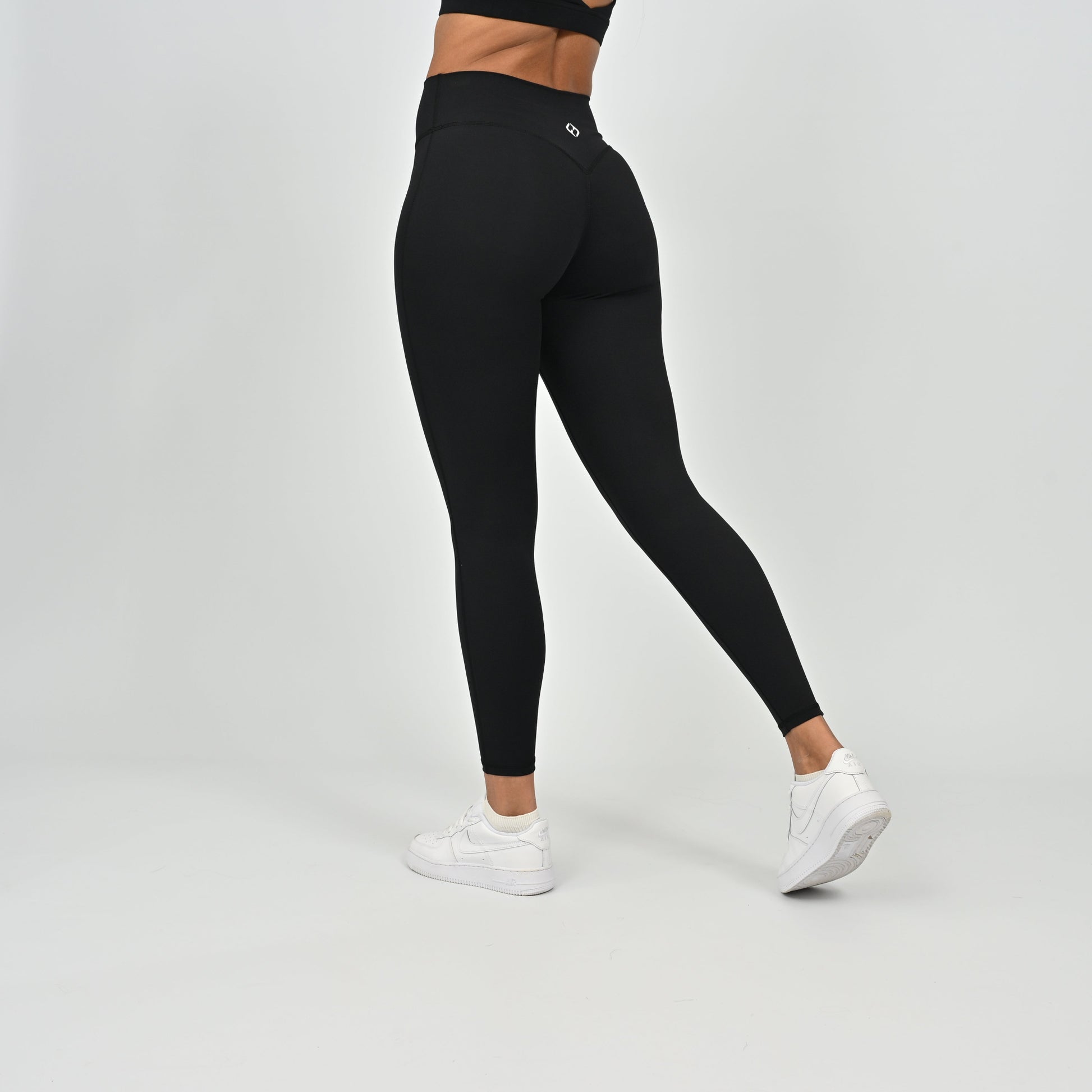 Person wearing black Hybryd leggings with a cinch