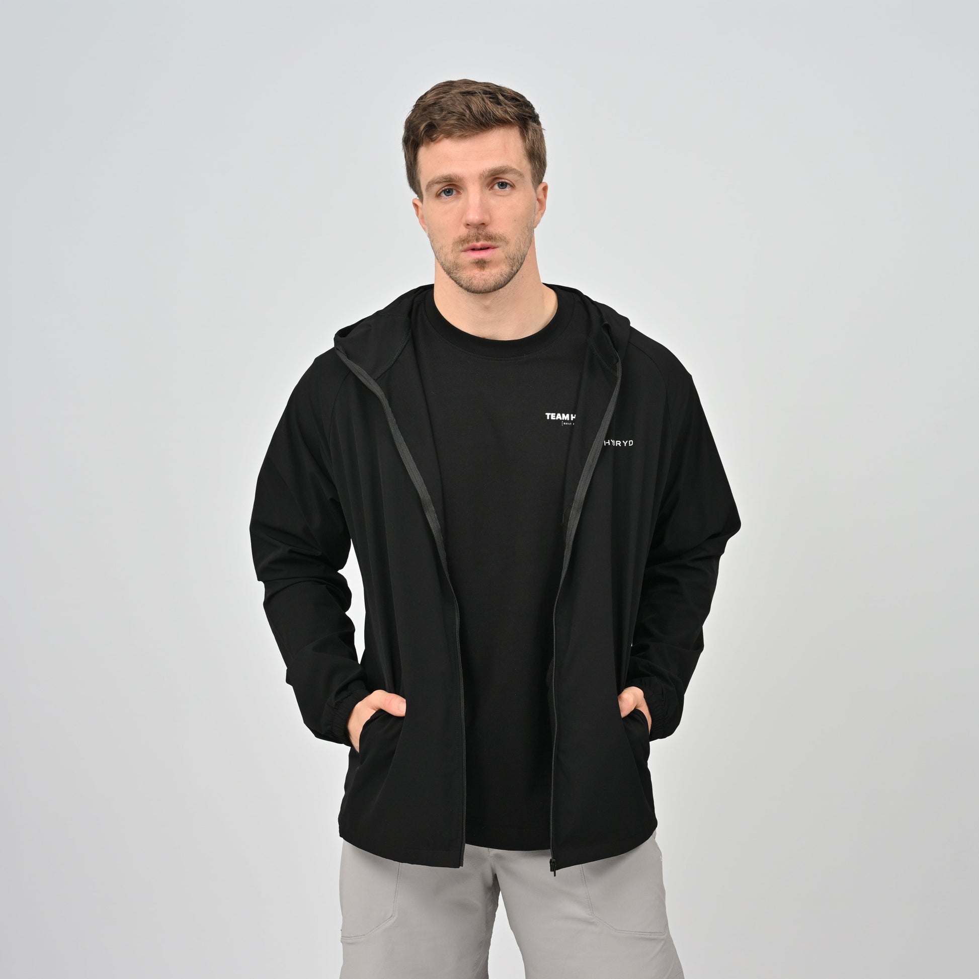 Hybryd guy wearing a black zip jacket with pockets