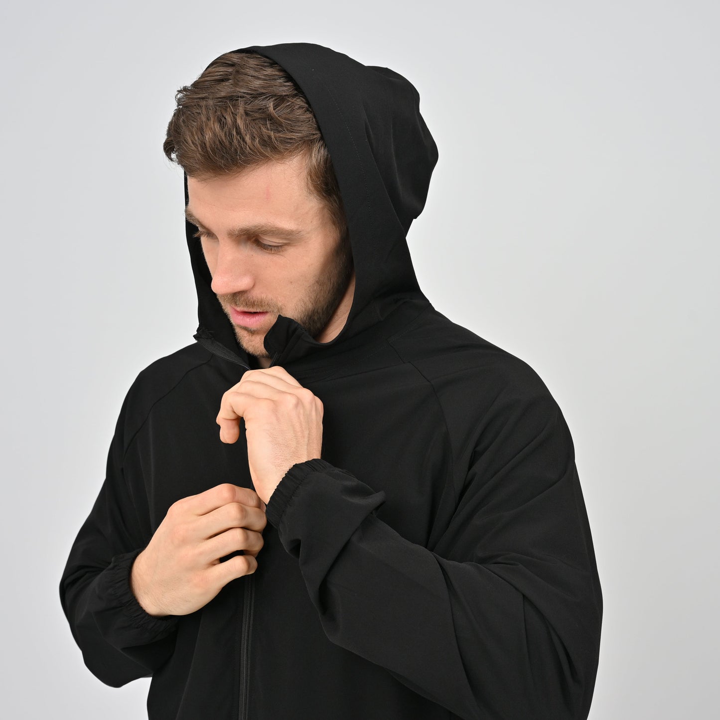 Man wearing a black lightweight hooded jacket