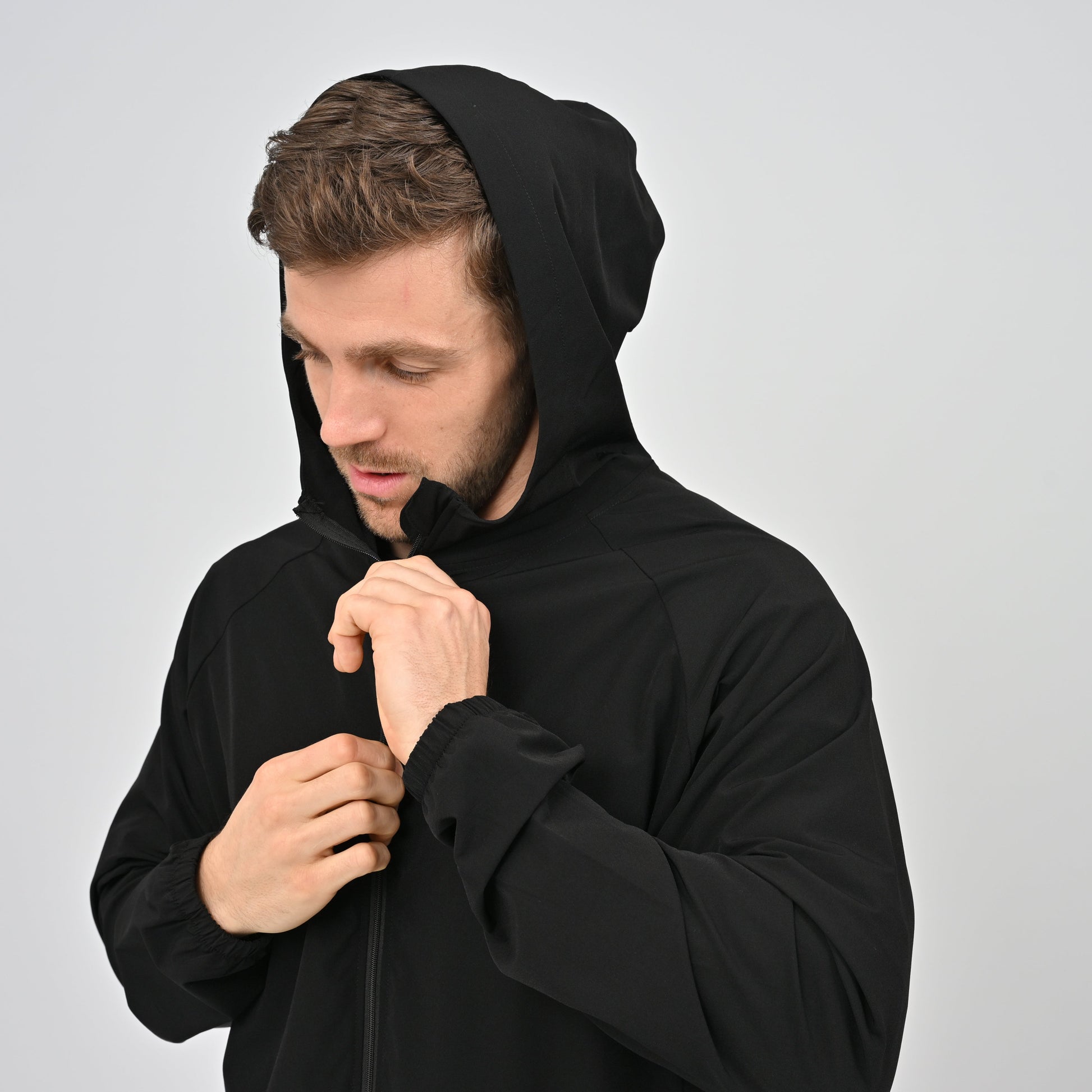 Man wearing a black lightweight hooded jacket