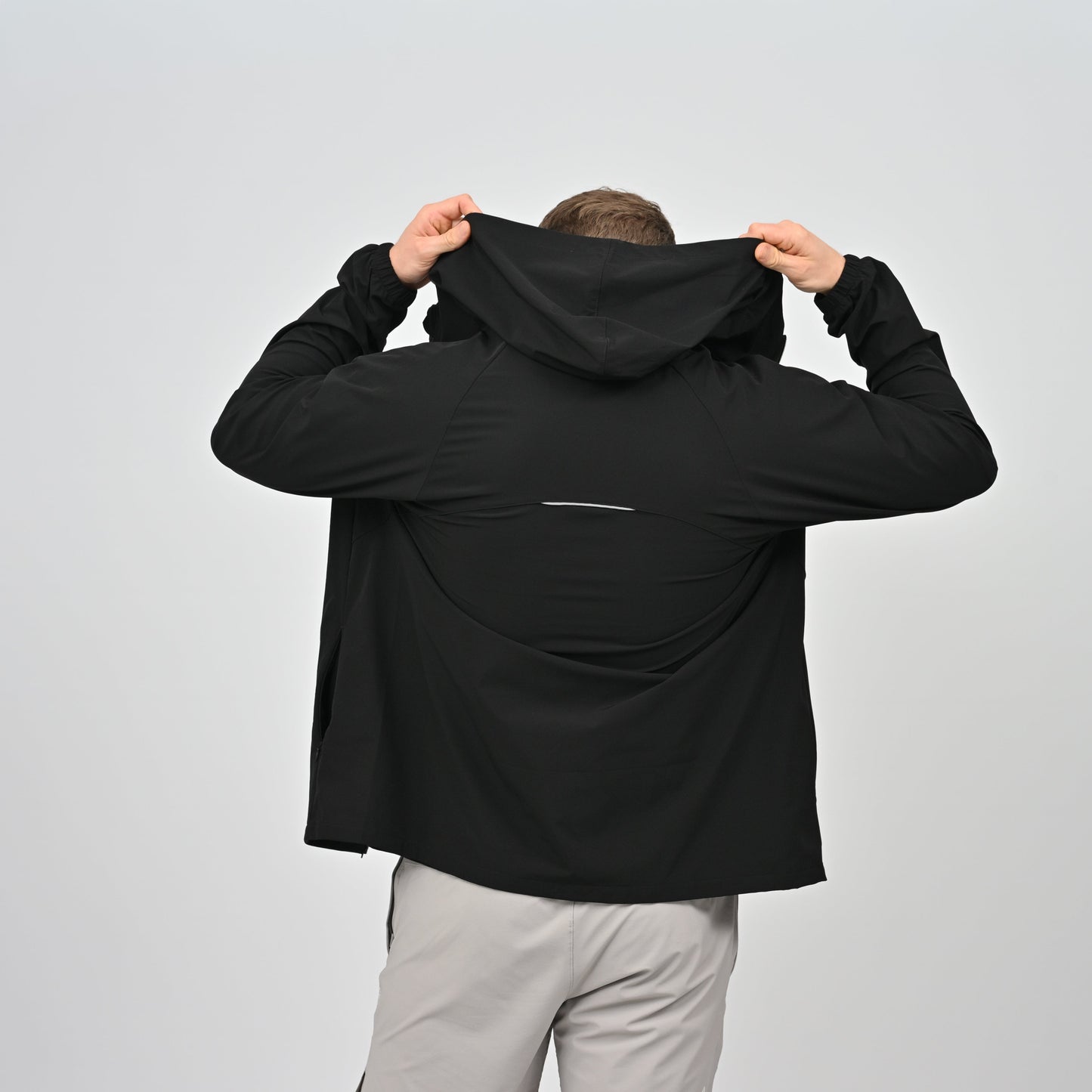 Hybryd athete wearing a black anorak with a hood