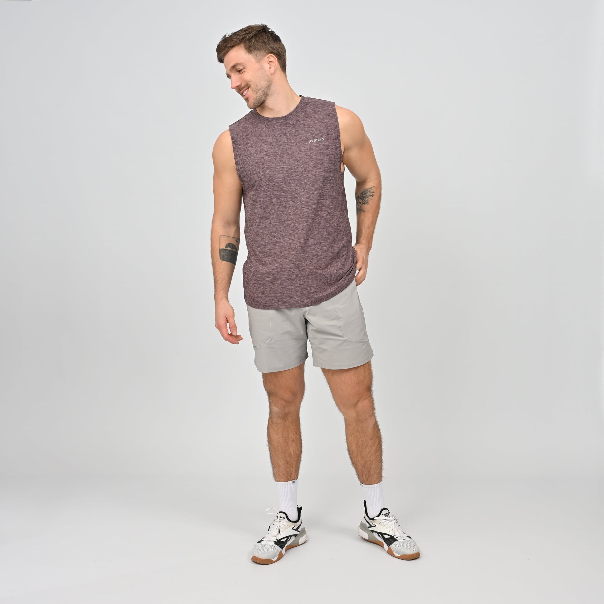 Man wearing a maroon sleeveless shirt and gray gym shorts from Hybryd