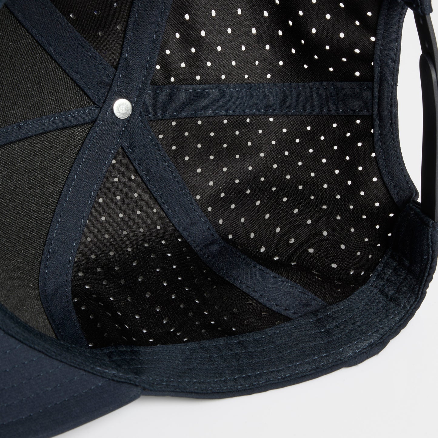 Close-up of the interior of a dark navy Hybryd baseball cap, showing a black mesh undercap.
