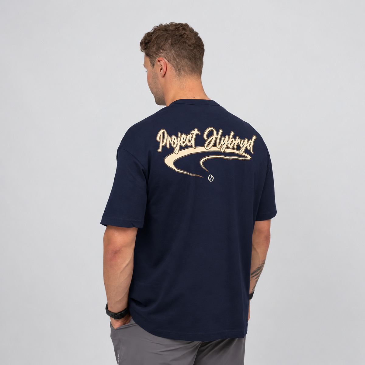 Men’s navy oversized gym T-shirt featuring a large cream Project Hybryd graphic across the back. Worn with Hybryd wod shorts.